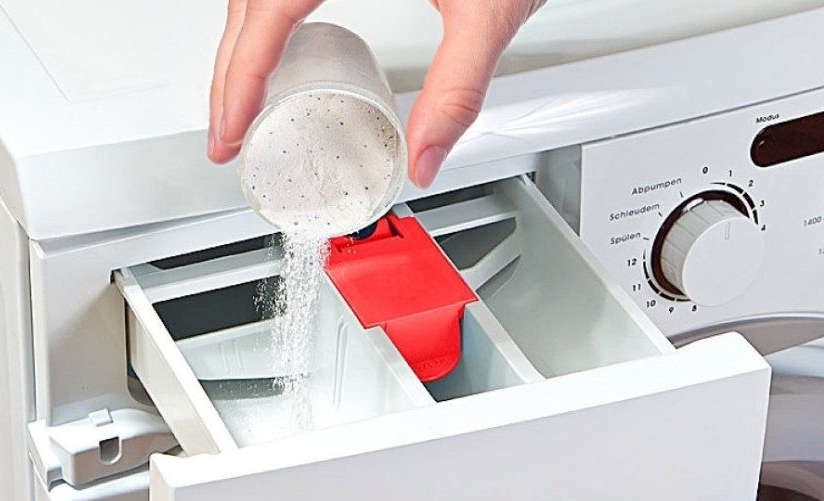 изсипете праха в тавата на машината Miele